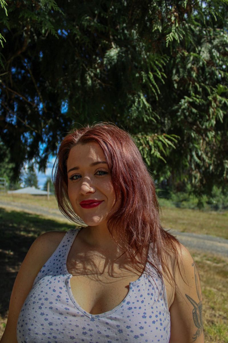 Close portrait of a smiling woman with red hair in warm sunlight