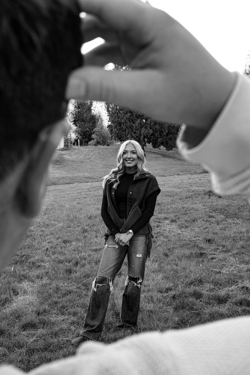 Black and white photo of a woman framed between her partner's hands