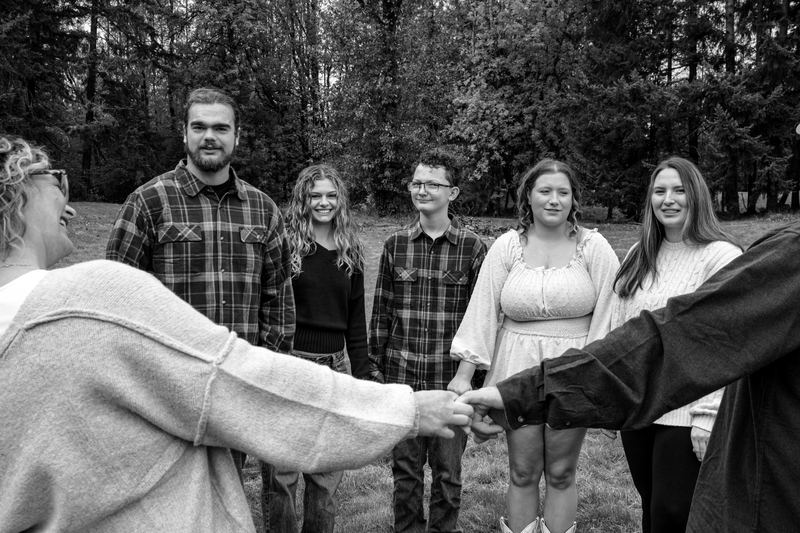 Black and white family photo, hands joined in the center